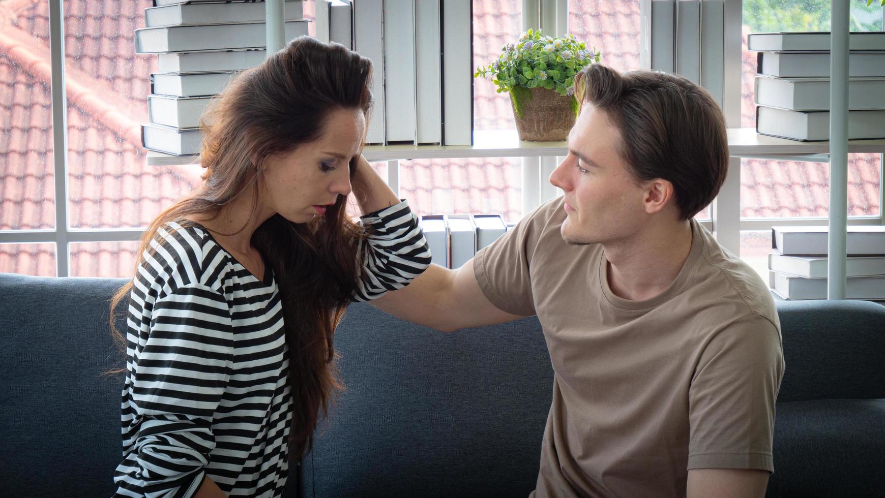 concepto de depresión y aliento. una mujer o novia se encuentra en un estado de ansiedad, tristeza, llanto, posiblemente debido a síntomas de depresión. un hombre o un novio consuela y alienta a una mujer. foto