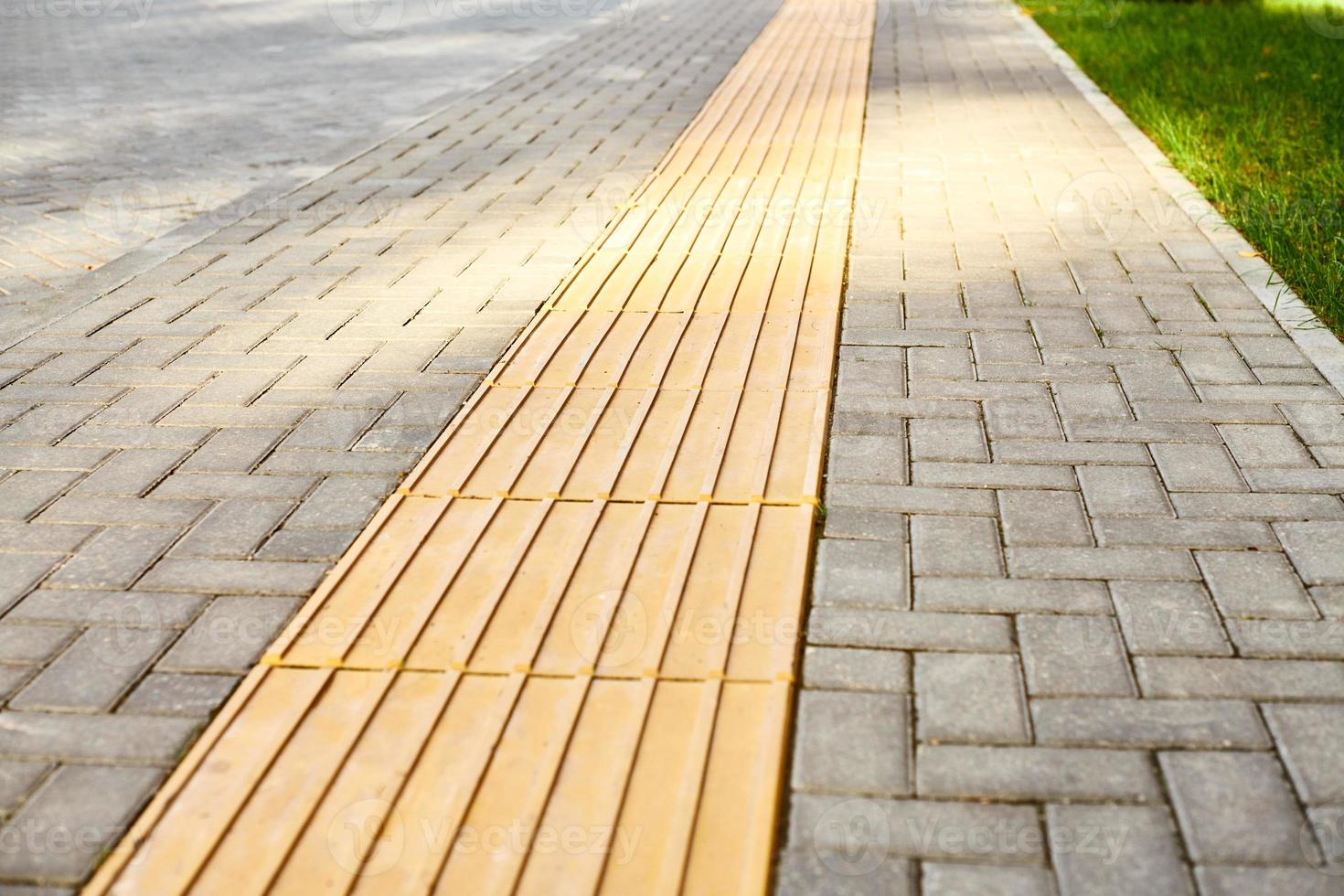 pavimentación táctil amarilla en la pasarela, indicadores táctiles de la superficie del suelo para ciegos y deficientes visuales foto