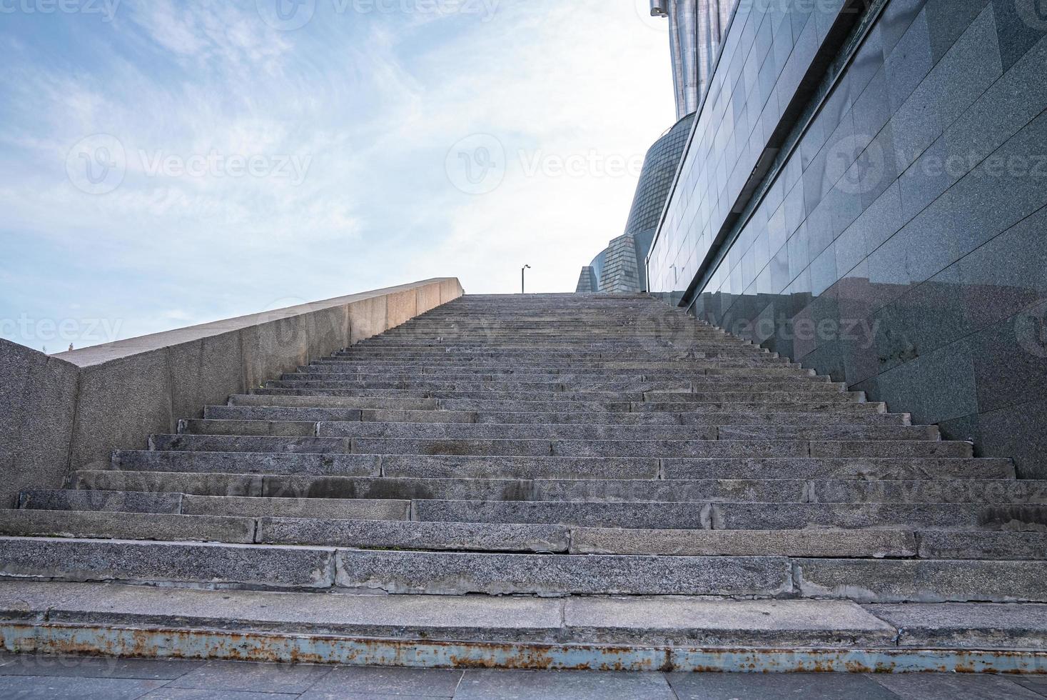 Empty granite staircases beside historical motherland monument sculpture photo