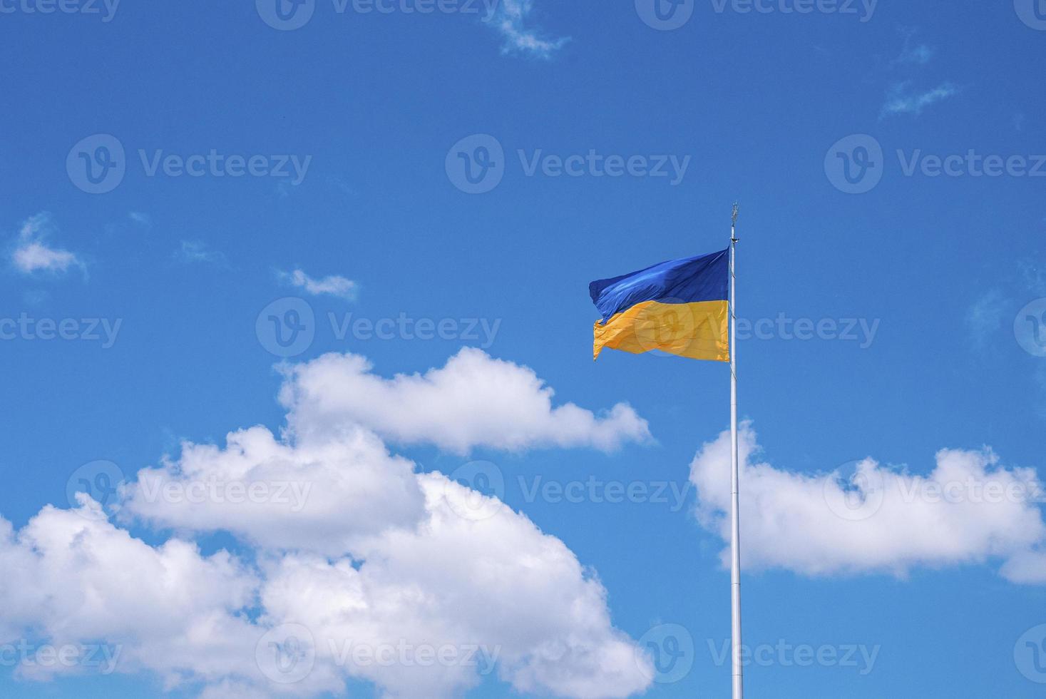Bicolor blue and yellow national flag of ukraine waving in wind against sky photo