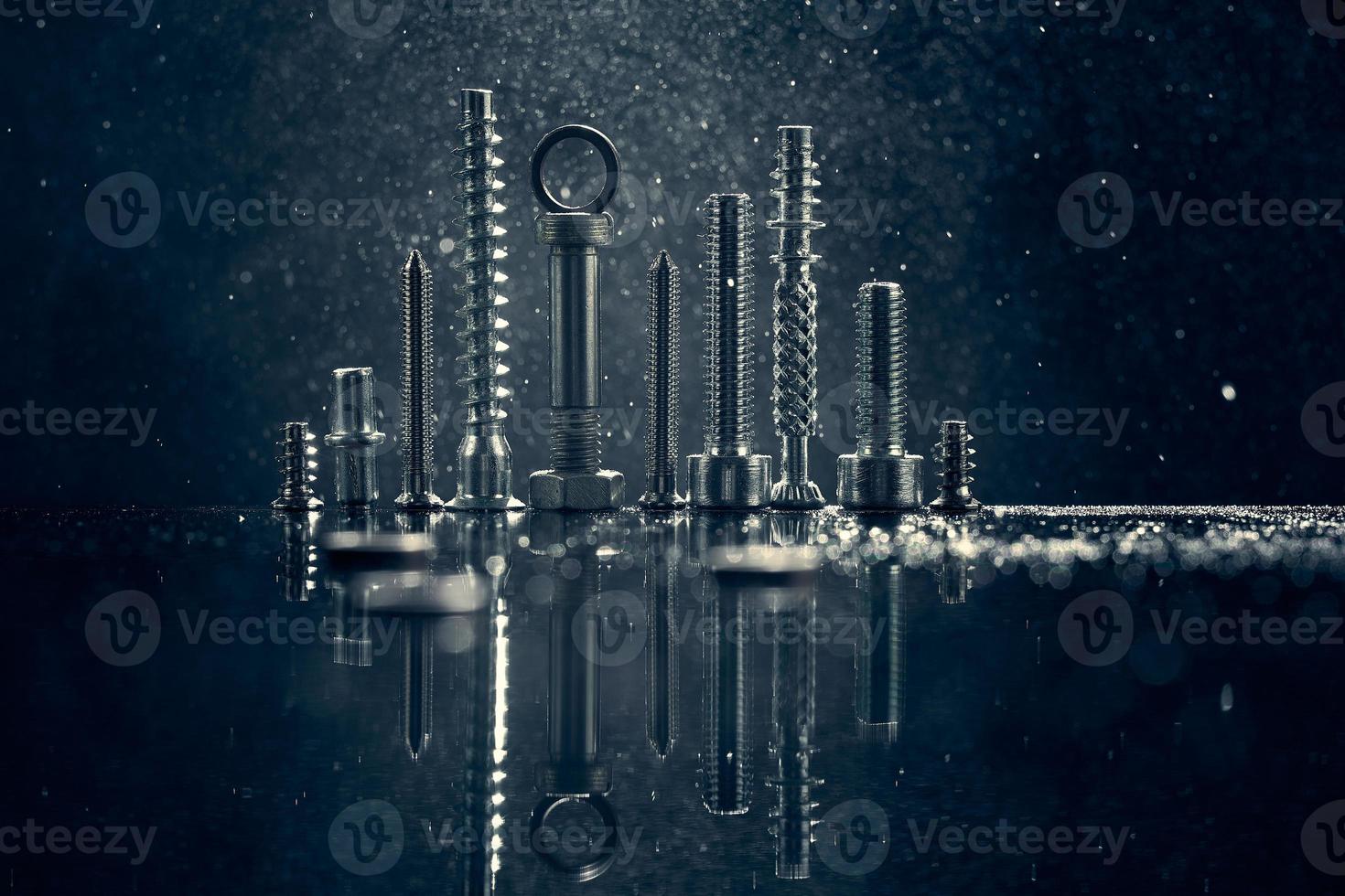 Abstract panorama of city with reflection, made by metal bolt and nut chrome. Black background with bokeh. photo