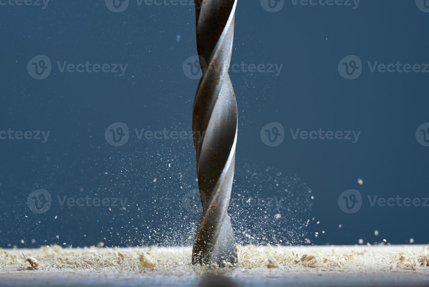 Wood drill bit in the blur with shaving on a gray background. Drill bit in the center of the frame. photo