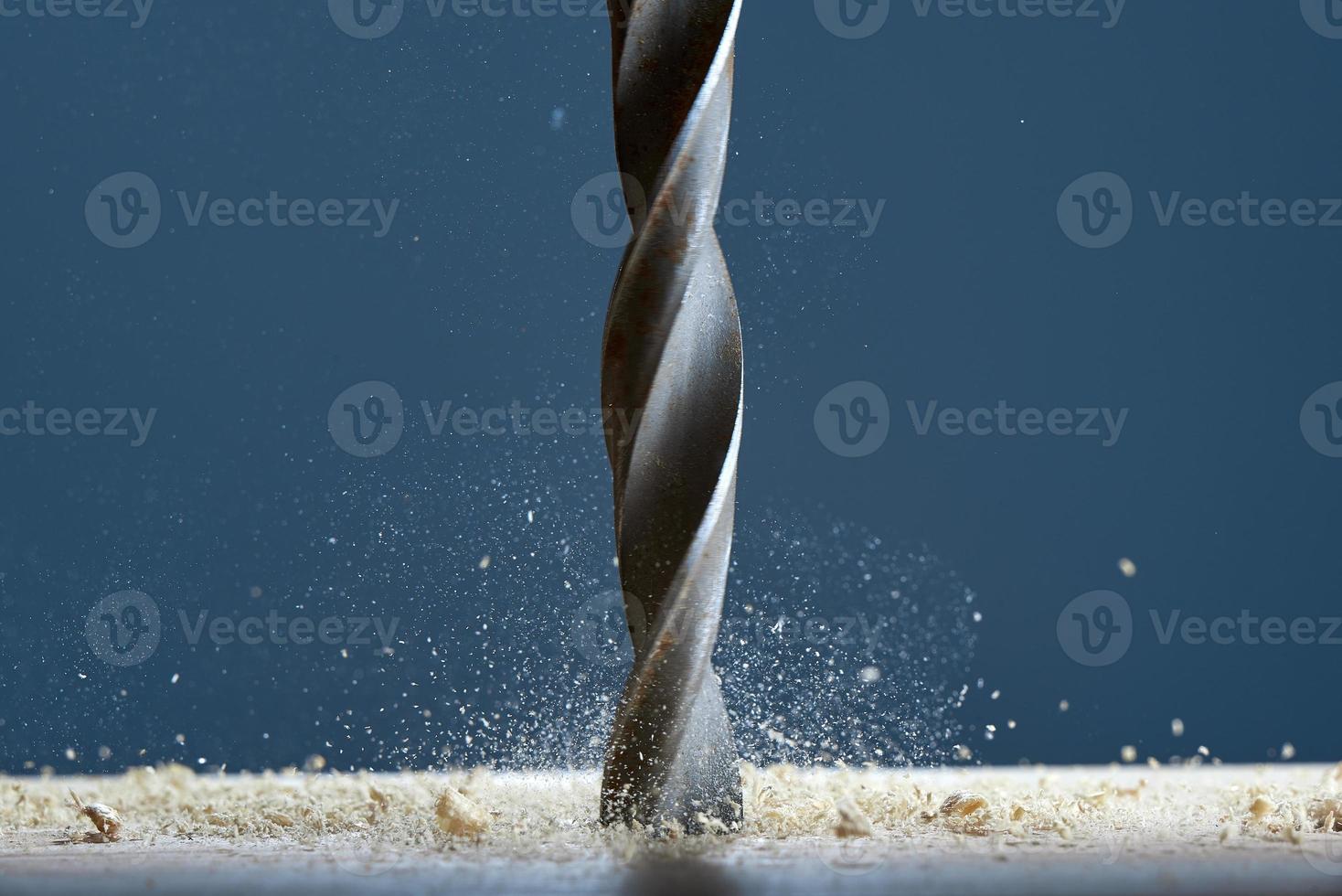 Wood drill bit in the blur with shaving on a gray background. Drill bit in the center of the frame. photo