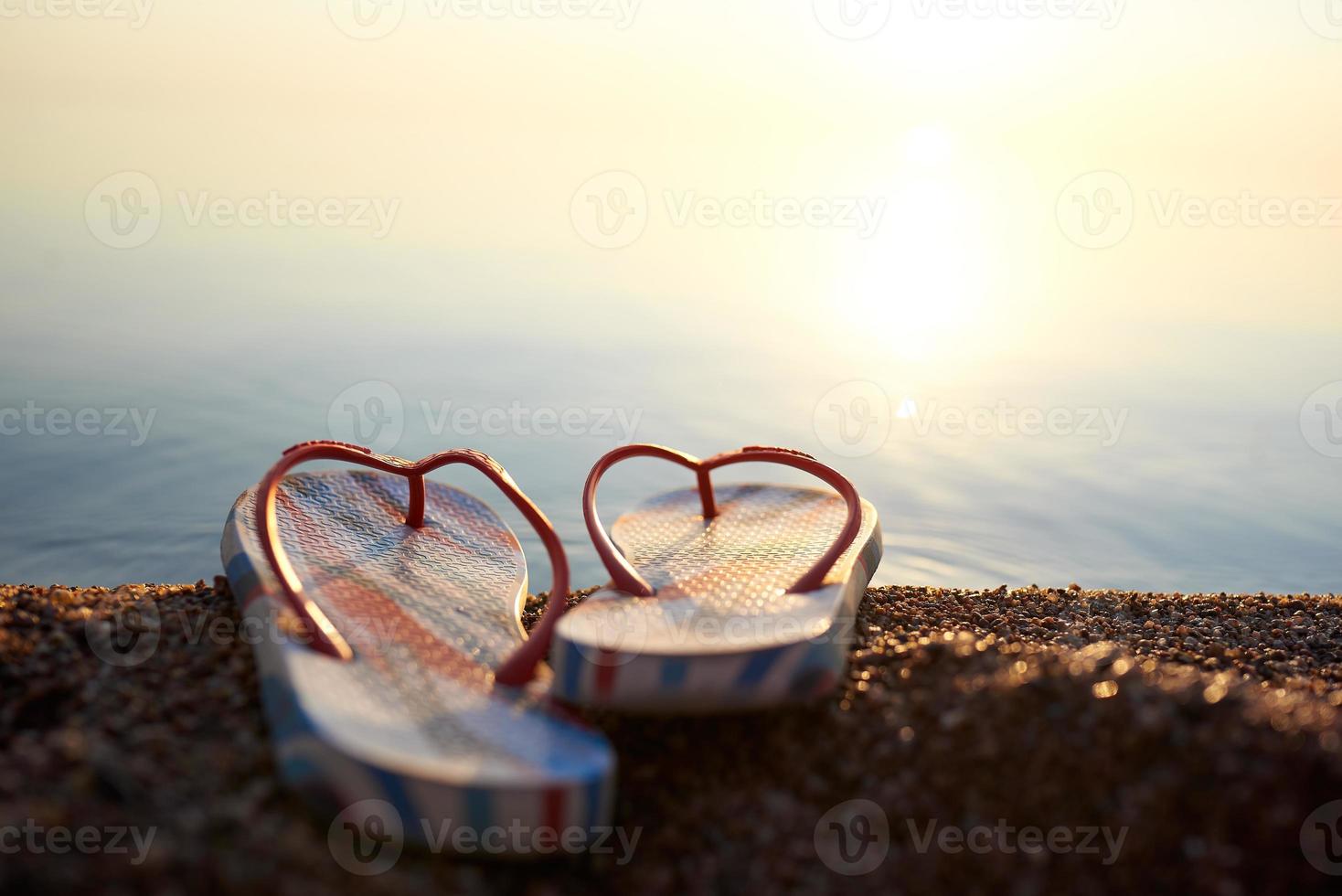 chanclas de playa en un primer plano de playa de guijarros contra el mar en un desenfoque. foto