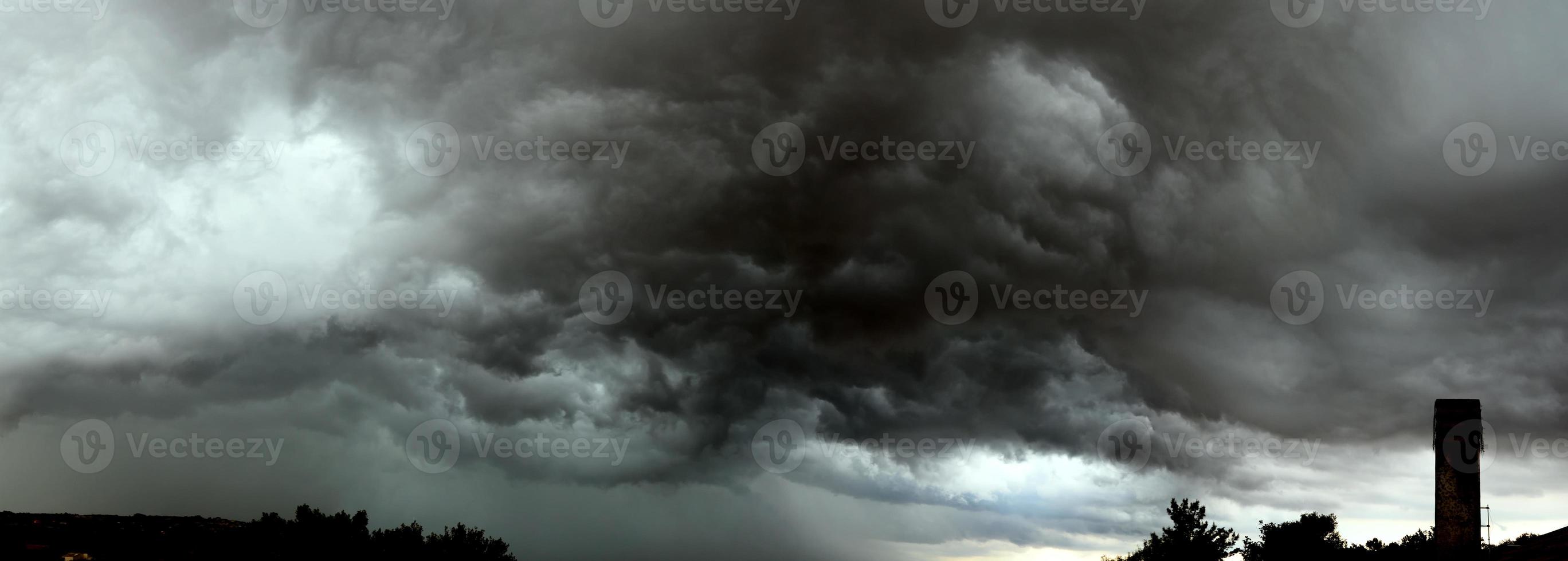 Danger storm clouds covering the sky with dark clouds. Ominous storm clouds.Storm clouds forming in the sky. photo