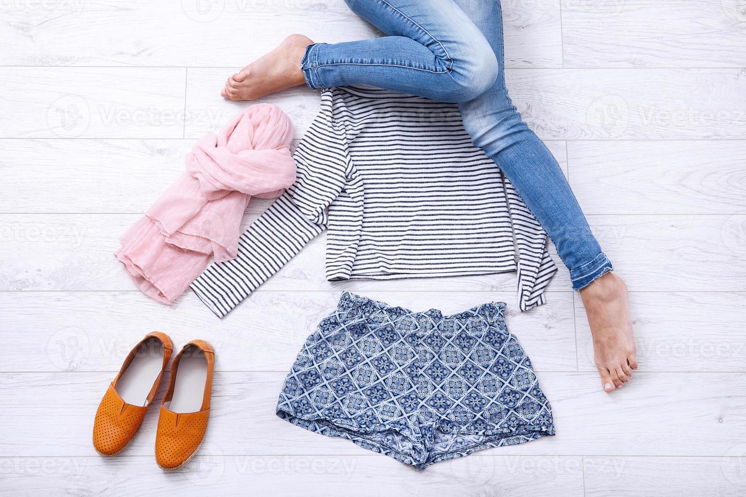 Collection collage of women's clothing and female legs on white wooden background. Top view photo