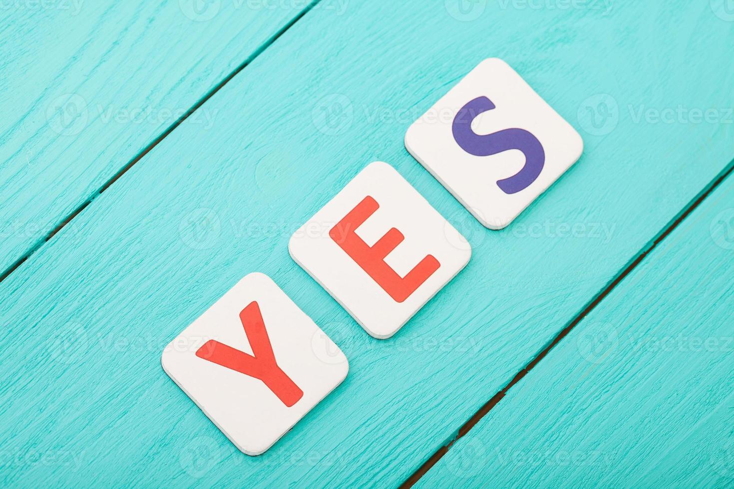 Word yes on blue wooden background. Top view. Mock up. Copy space. Success concept photo