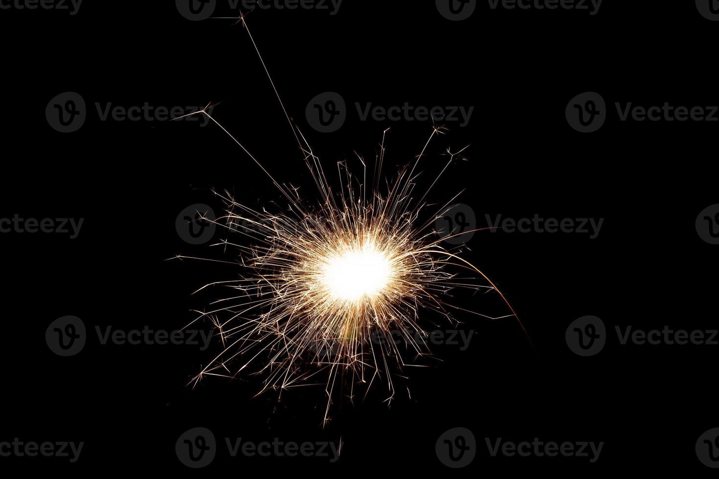 Burning sparkler isolated on black background. Fireworks theme. Light effect and texture. photo