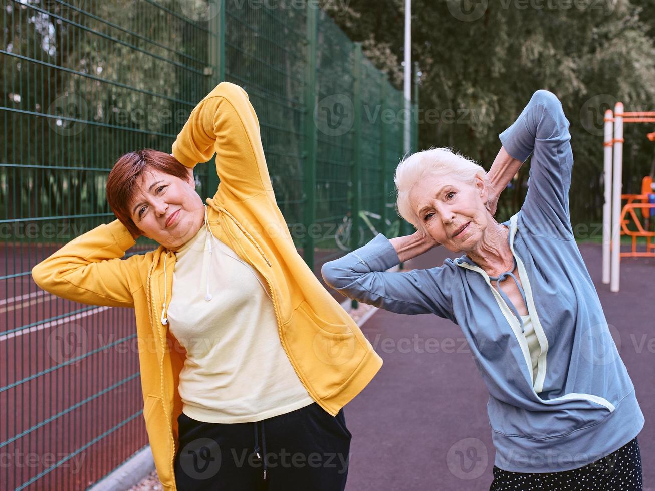 two mature women doing sport exercises in the park. healthy lifestyle concept photo