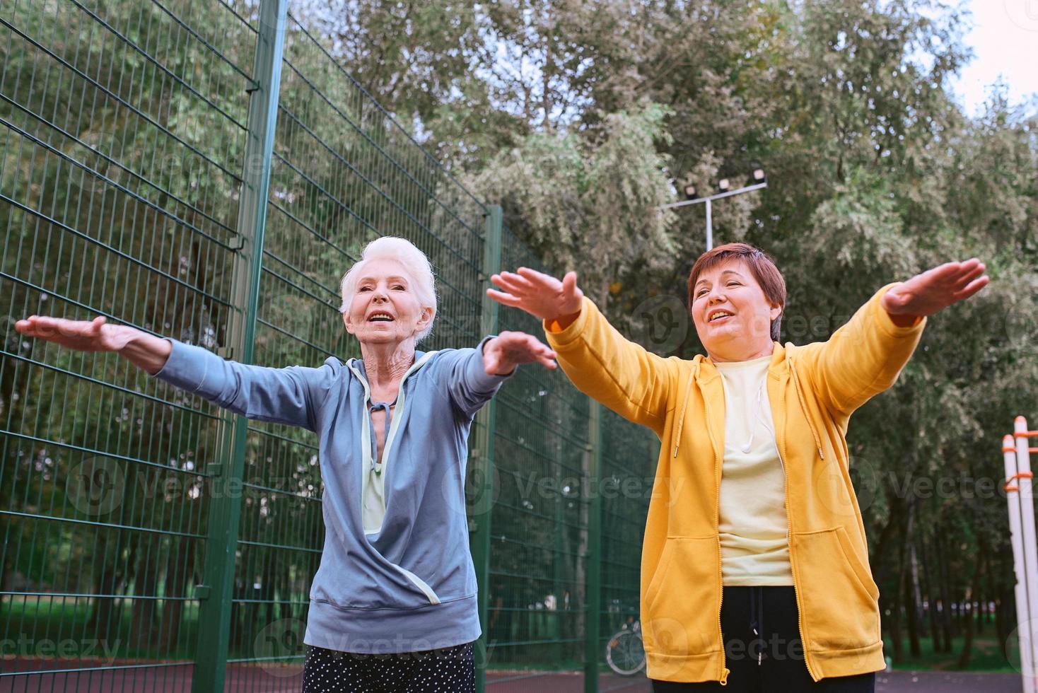 two mature women doing sport exercises in the park. healthy lifestyle concept photo