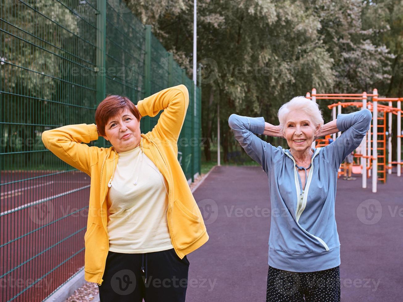 dos mujeres maduras haciendo ejercicios deportivos en el parque. concepto de estilo de vida saludable foto