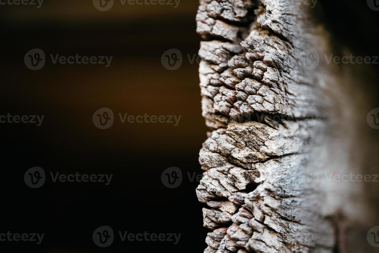 Macro texture of old wooden planks used to build houses that look dry and cracked. Empty space to enter text. Black background. Vintage image. photo