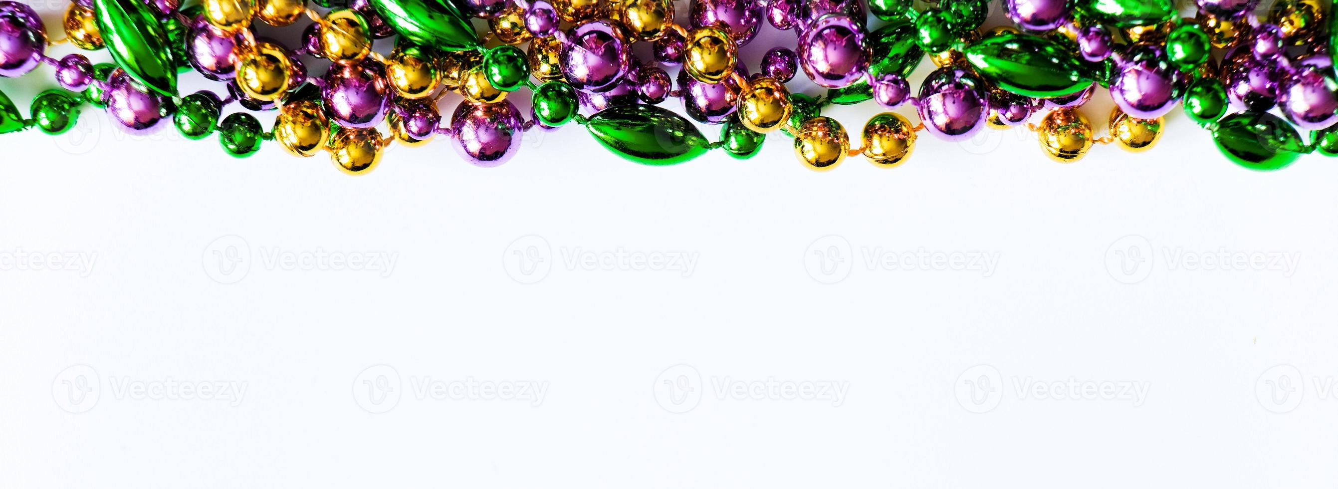 Gold, green and purple beads on white background. photo