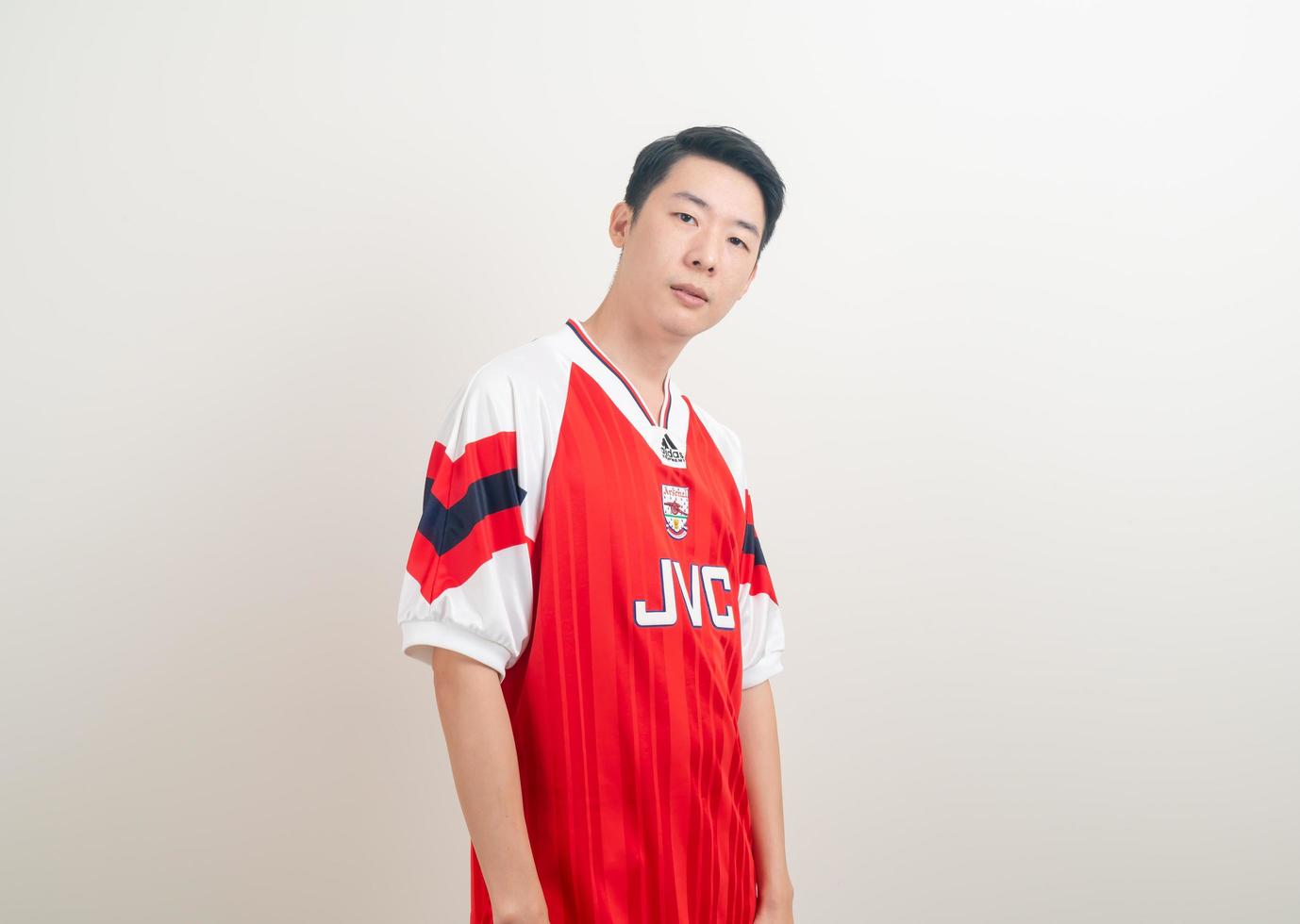 Bangkok, THAILAND - Nov 27, 2021 - Young Asian man wearing Arsenal shirt with white background. photo