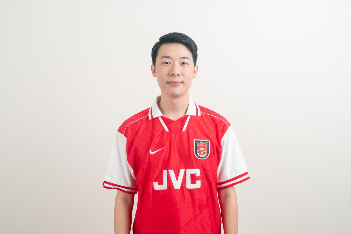 Bangkok, THAILAND - Nov 27, 2021 - Young Asian man wearing Arsenal shirt with white background. photo