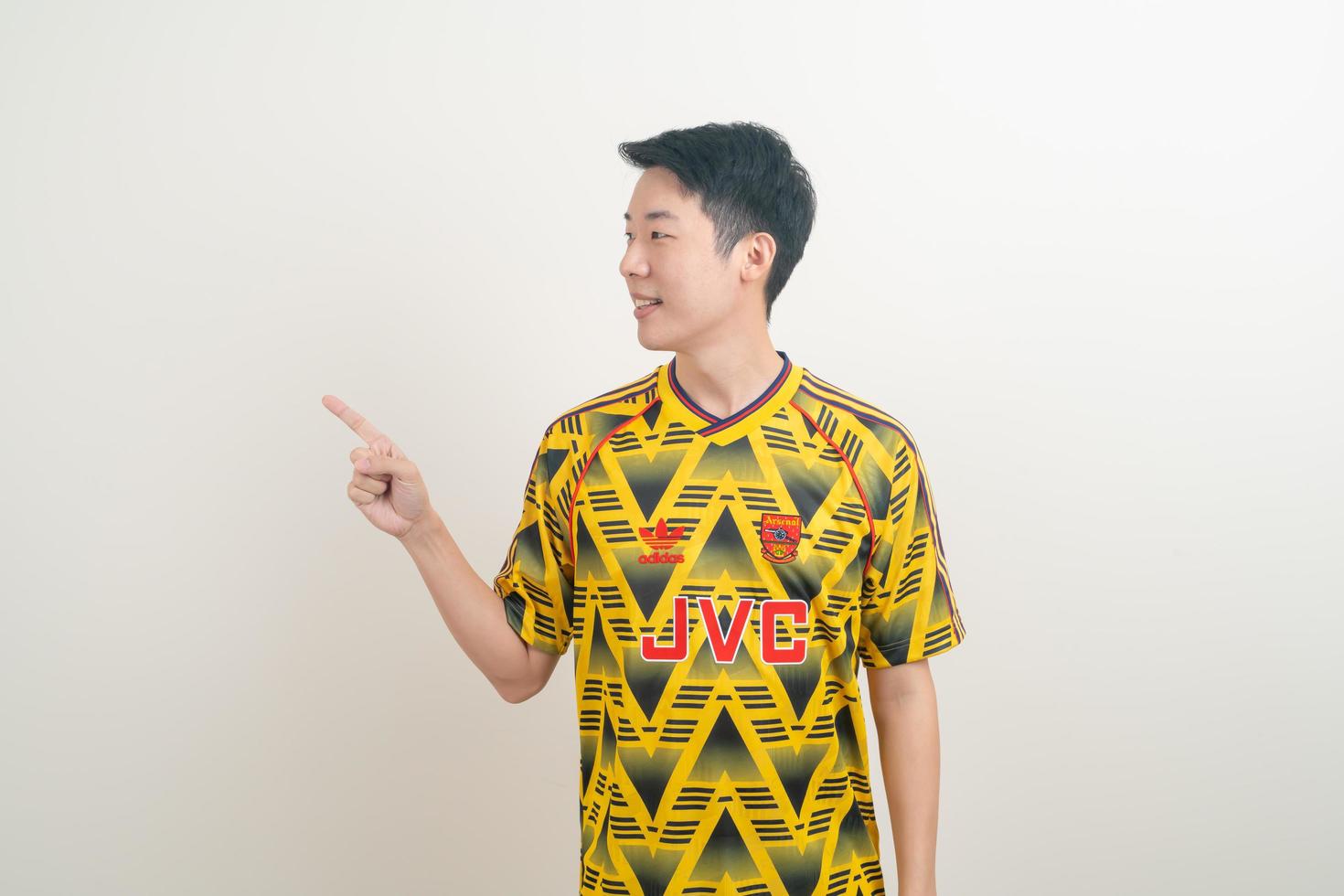 Bangkok, THAILAND - Nov 27, 2021 - Young Asian man wearing Arsenal shirt with white background. photo