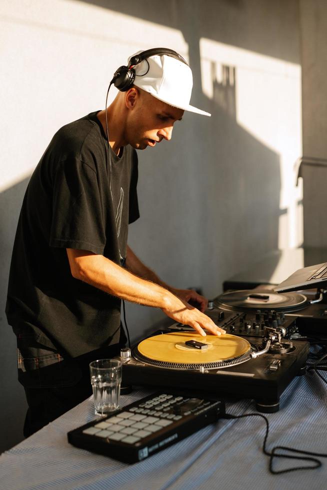 dj en auriculares juega en un evento en discos de vinilo foto