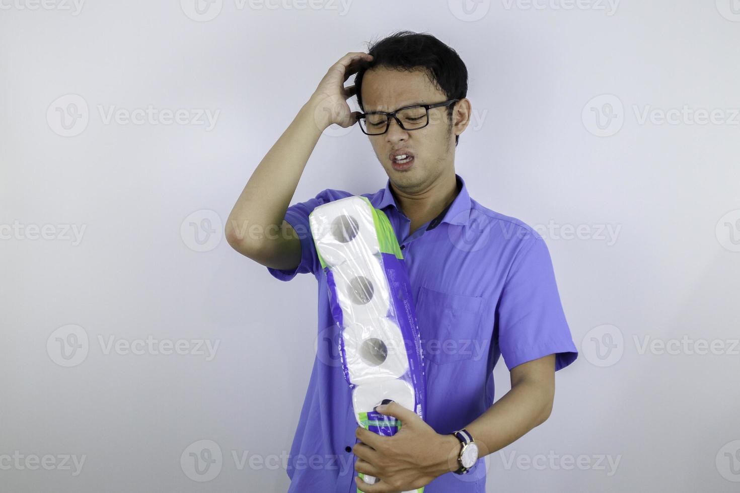 Asian Man is mad and angry when shopping bag with tissue toilet paper rolls. Buying panic for home quarantine due to coronavirus. Stay at home for covid-19 protection concept. photo