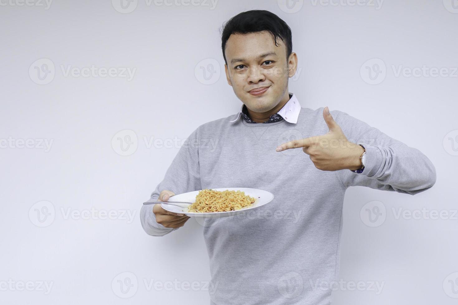 Portrait of happy Young Asian man enjoys noodles. Eating lunch concept photo