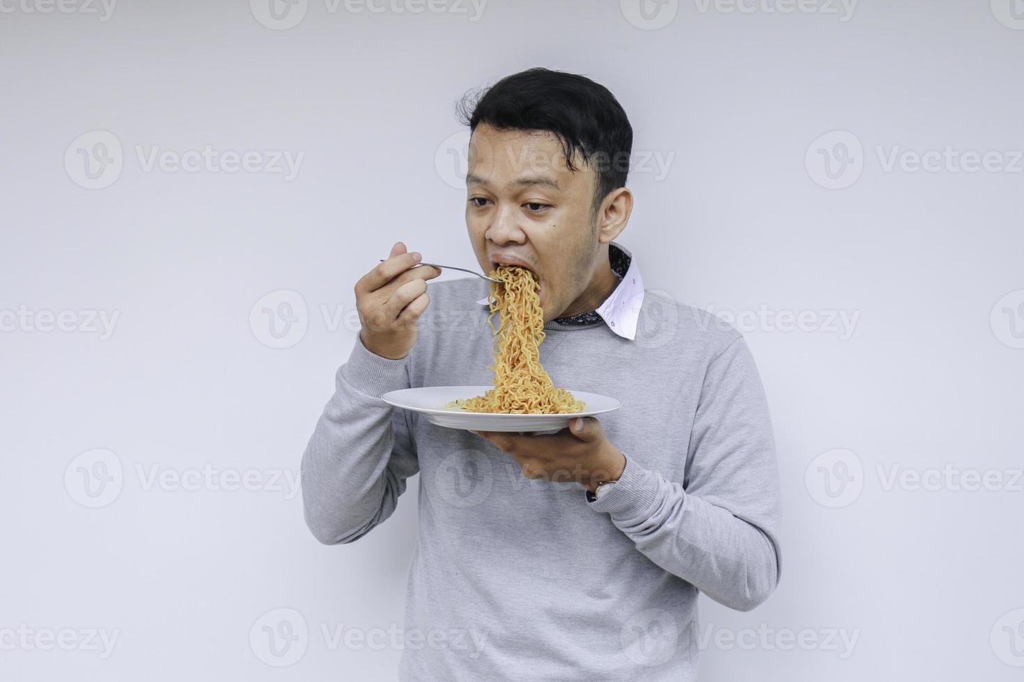 Young Asian man enjoy noodles. Eating lunch concept. photo