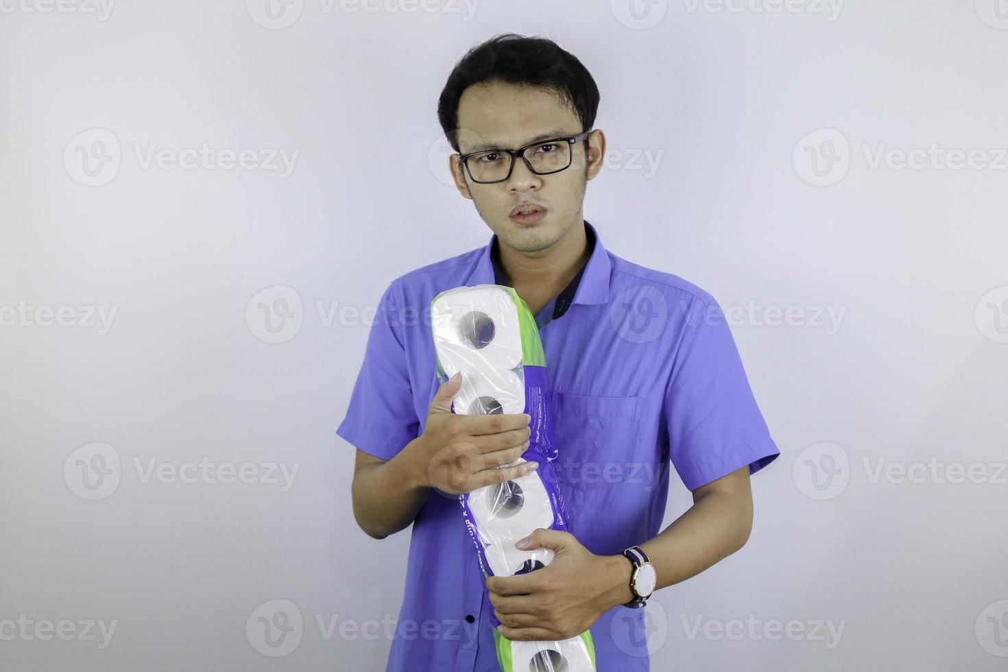 Asian Man is mad and angry when shopping bag with tissue toilet paper rolls. Buying panic for home quarantine due to coronavirus. Stay at home for covid-19 protection concept. photo
