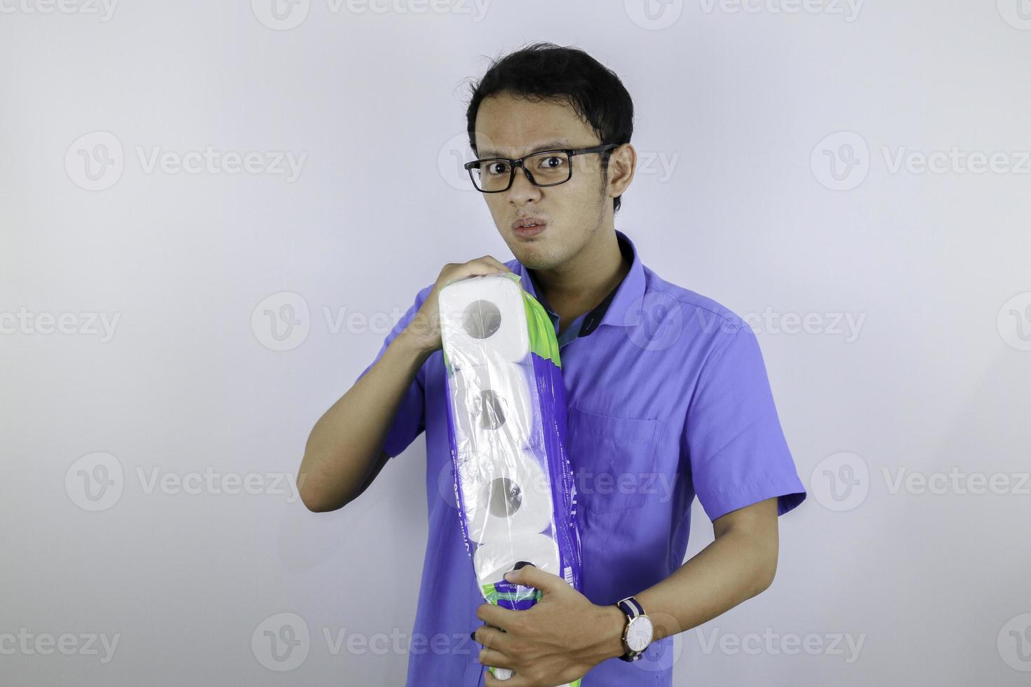 Asian Man is mad and angry when shopping bag with tissue toilet paper rolls. Buying panic for home quarantine due to coronavirus. Stay at home for covid-19 protection concept. photo