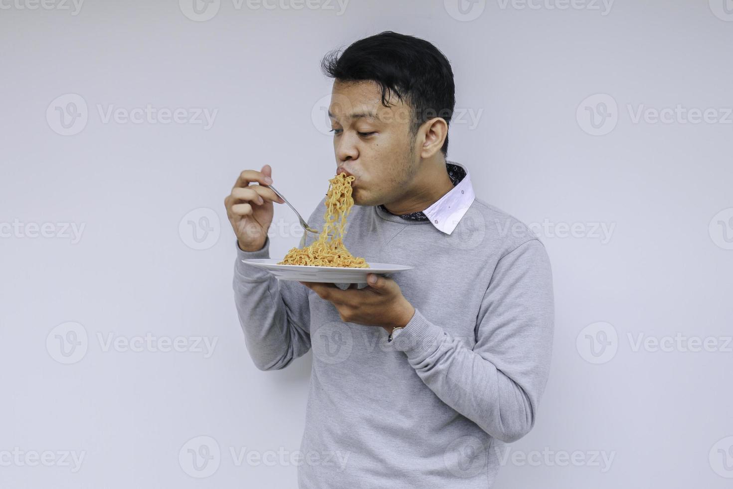 Young Asian man enjoy noodles. Eating lunch concept. photo