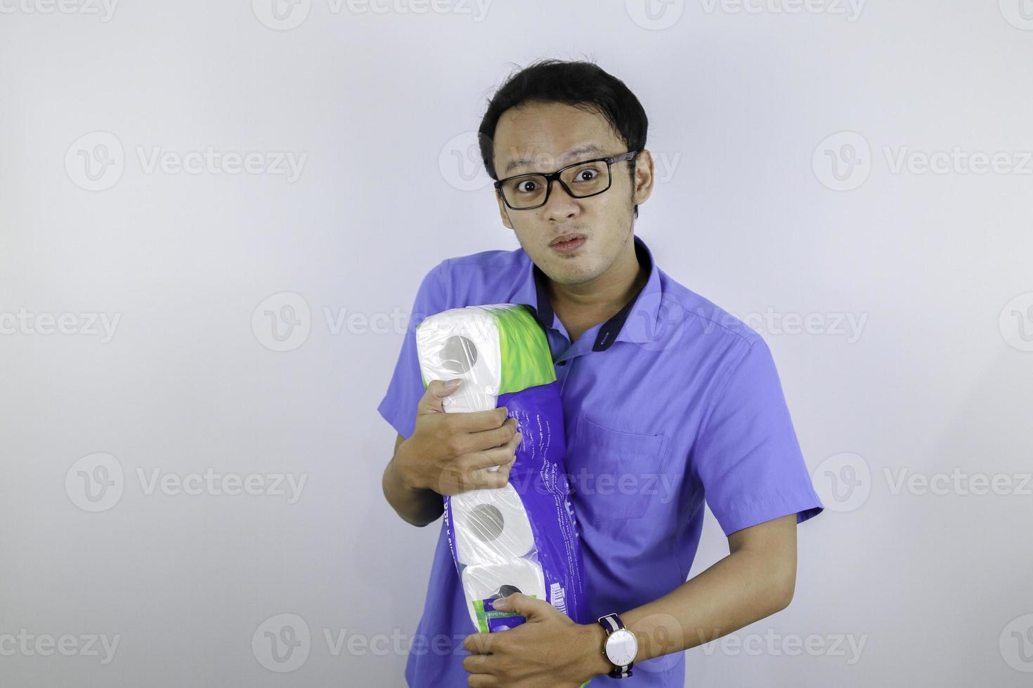 Asian Man is mad and angry when shopping bag with tissue toilet paper rolls. Buying panic for home quarantine due to coronavirus. Stay at home for covid-19 protection concept. photo
