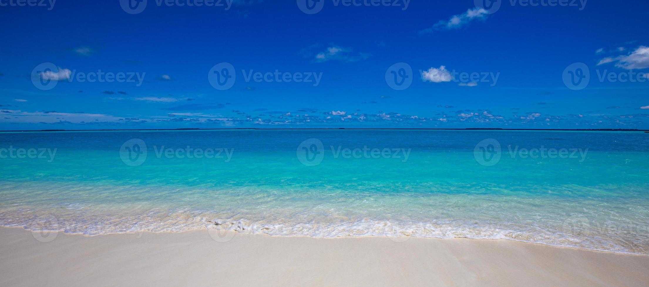 Closeup of sand on beach and blue summer sky. Panoramic beach landscape. Empty tropical beach and seascape. Bright blue sky, soft sand, calmness, tranquil relaxing sunlight, summer mood photo