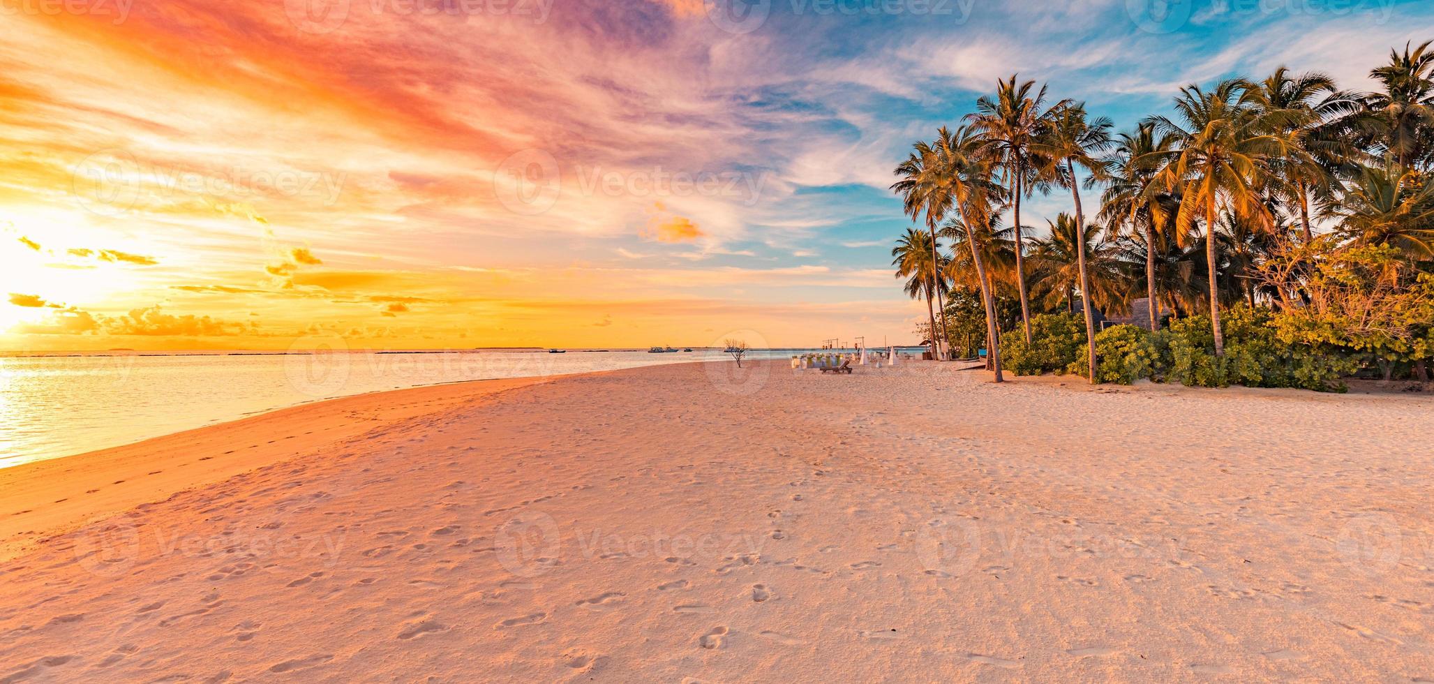 tranquilo paisaje de vacaciones de vacaciones de verano. playa de la puesta del sol de la isla tropical. palmeras orilla mar en calma arena. naturaleza exótica escénica, inspiradora y pacífica reflexión del paisaje marino, asombrosa puesta de sol en el cielo foto