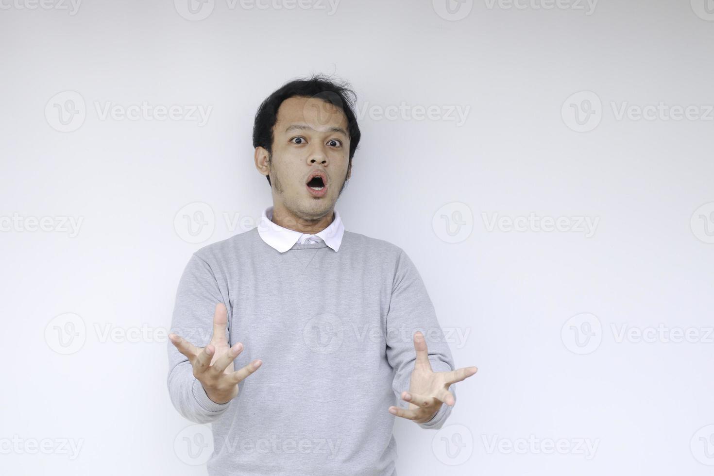 Wow and shocked face of Young Asian man with open hand gesture. Advertising model concept. photo