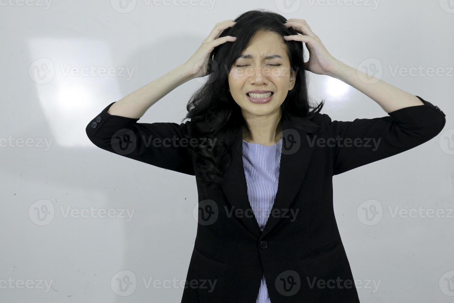 La joven asiática de negocios está estresada y confundida con su trabajo aislada de fondo blanco foto