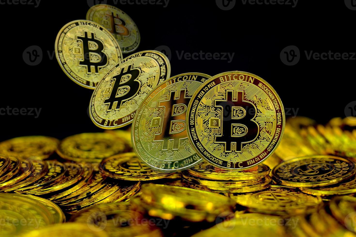 Golden bitcoin cryptocurrency on stack gold coin at black background photo