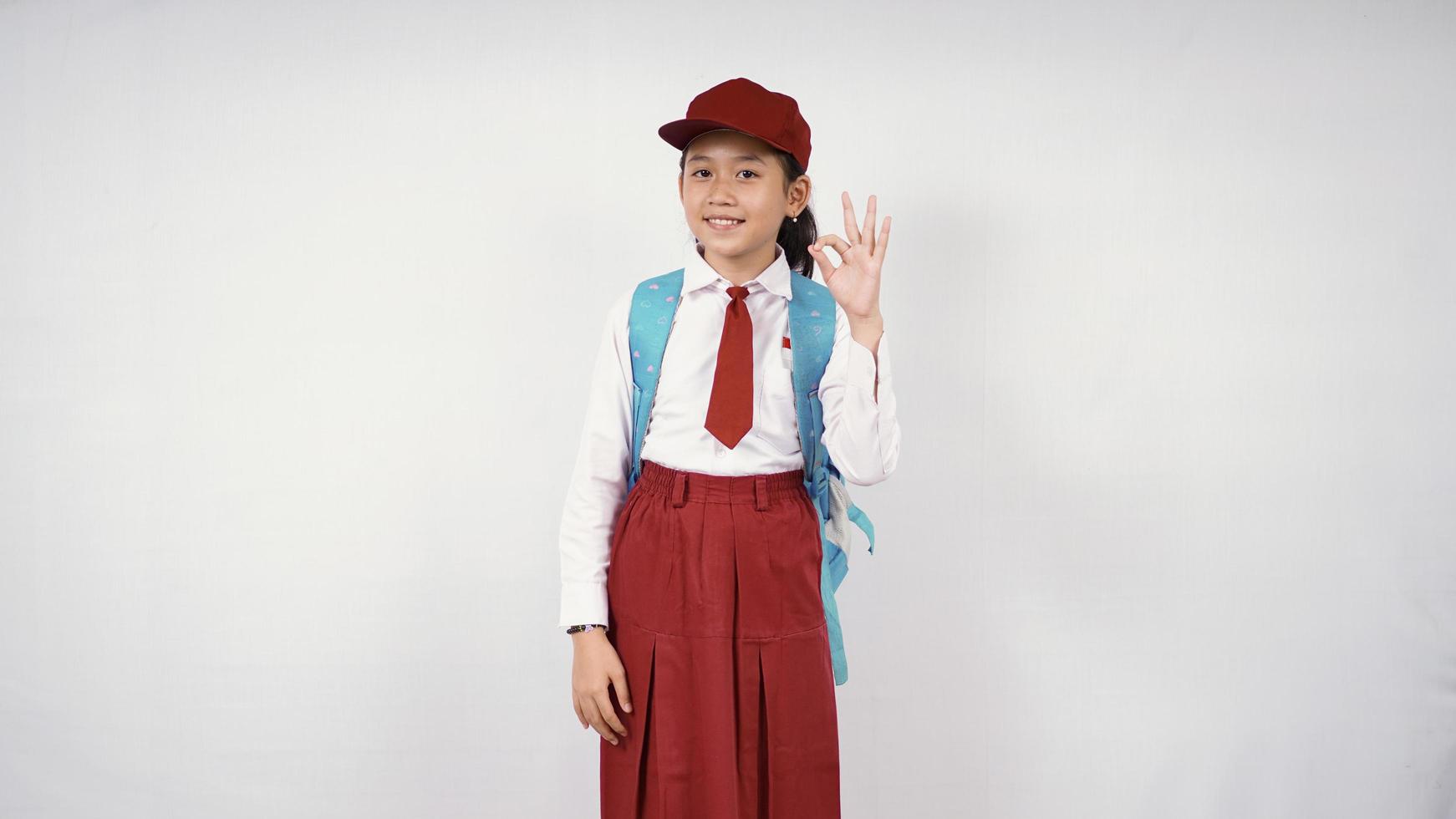 una niña de la escuela primaria asiática se siente bien aislada de fondo blanco foto