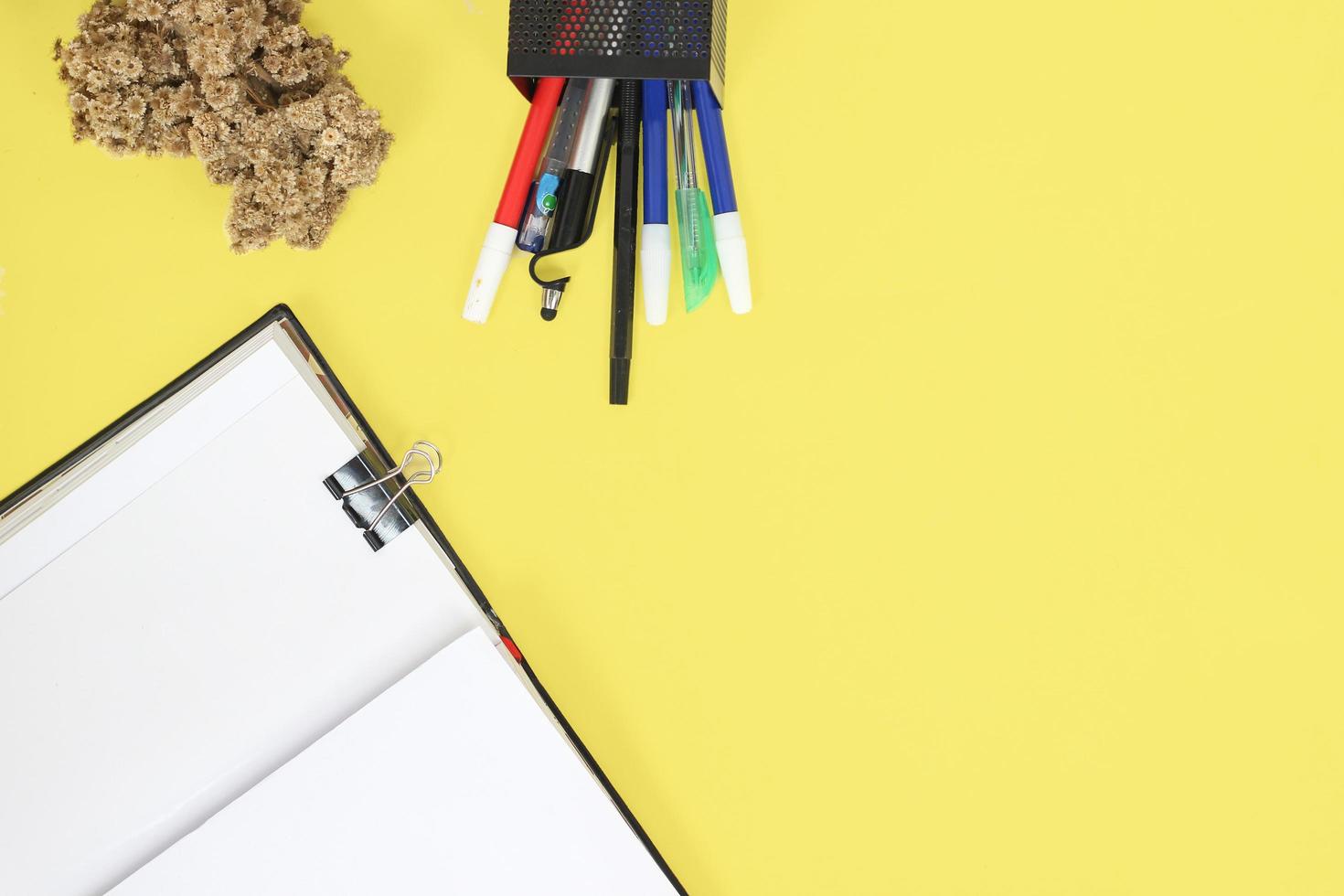 work desk full of stationery isolated on yellow background photo