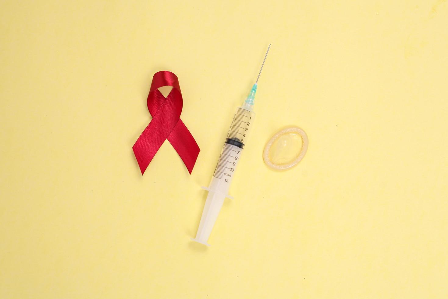 red ribbon and medical device symbol against HIV isolated on yellow background photo