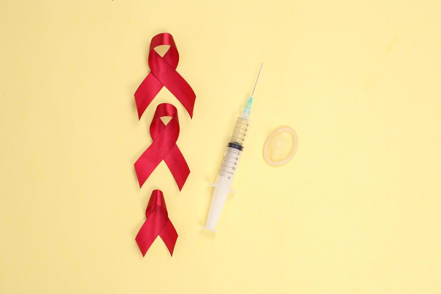 red ribbon and medical device symbol against HIV isolated on yellow background photo