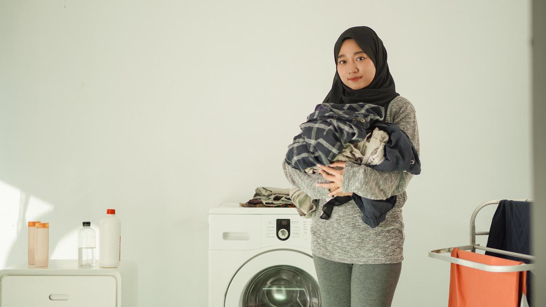 mujer asiática en hiyab trae su ropa a casa foto