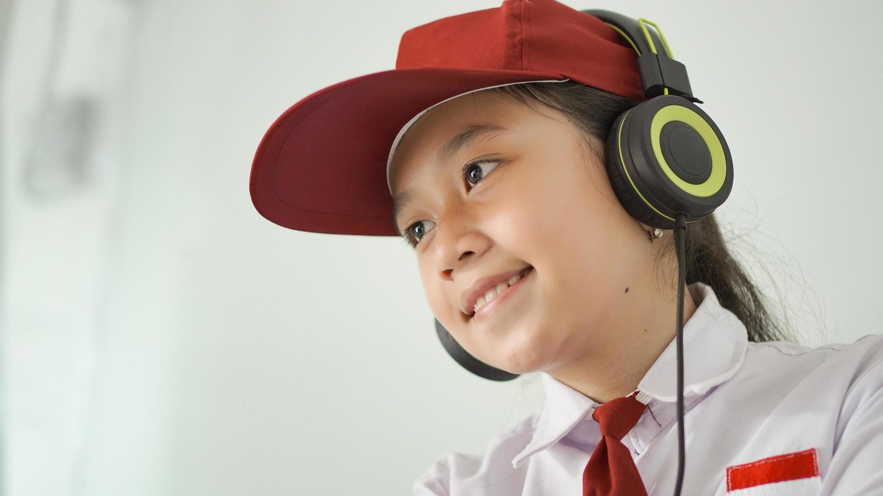 asian elementary school girl studying online at home happily photo