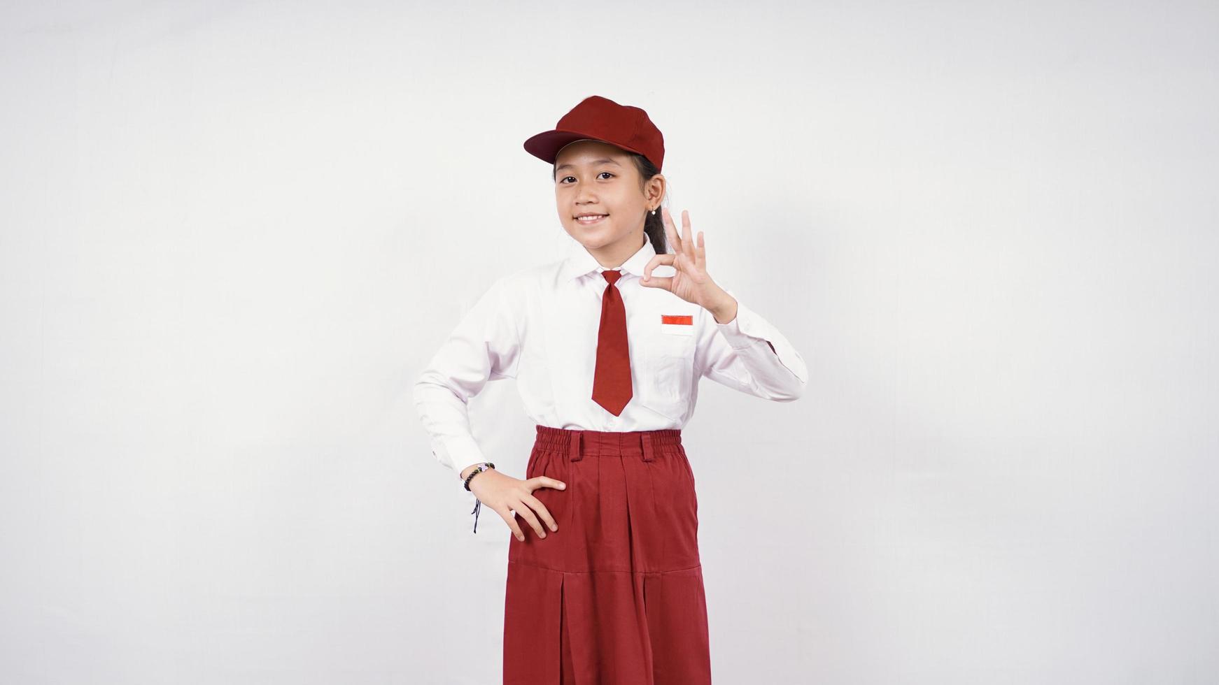 sonriente y bien niña de la escuela primaria asiática aislada sobre fondo blanco foto