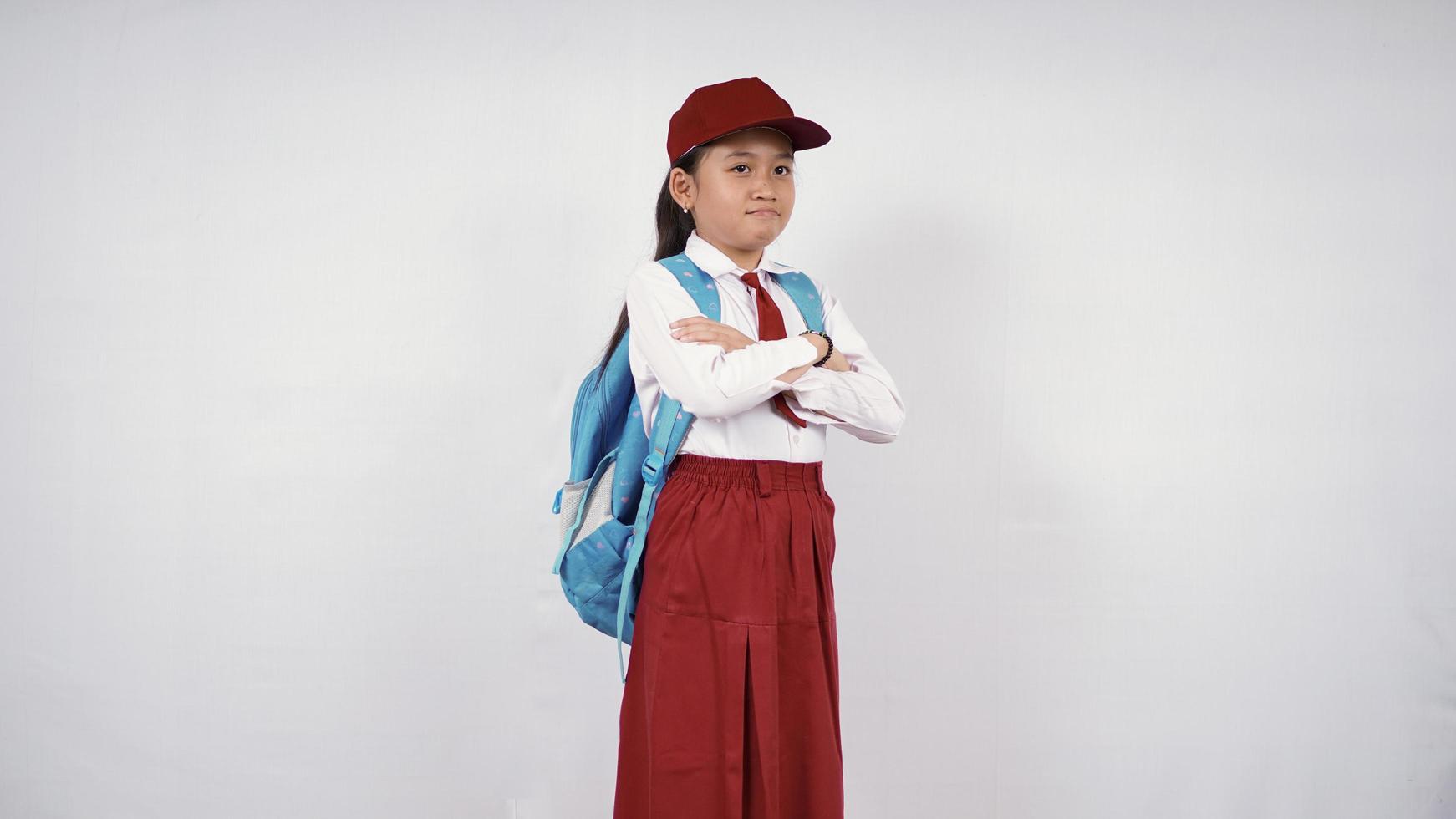 hermosa niña de la escuela primaria que se siente molesta aislada de fondo blanco foto