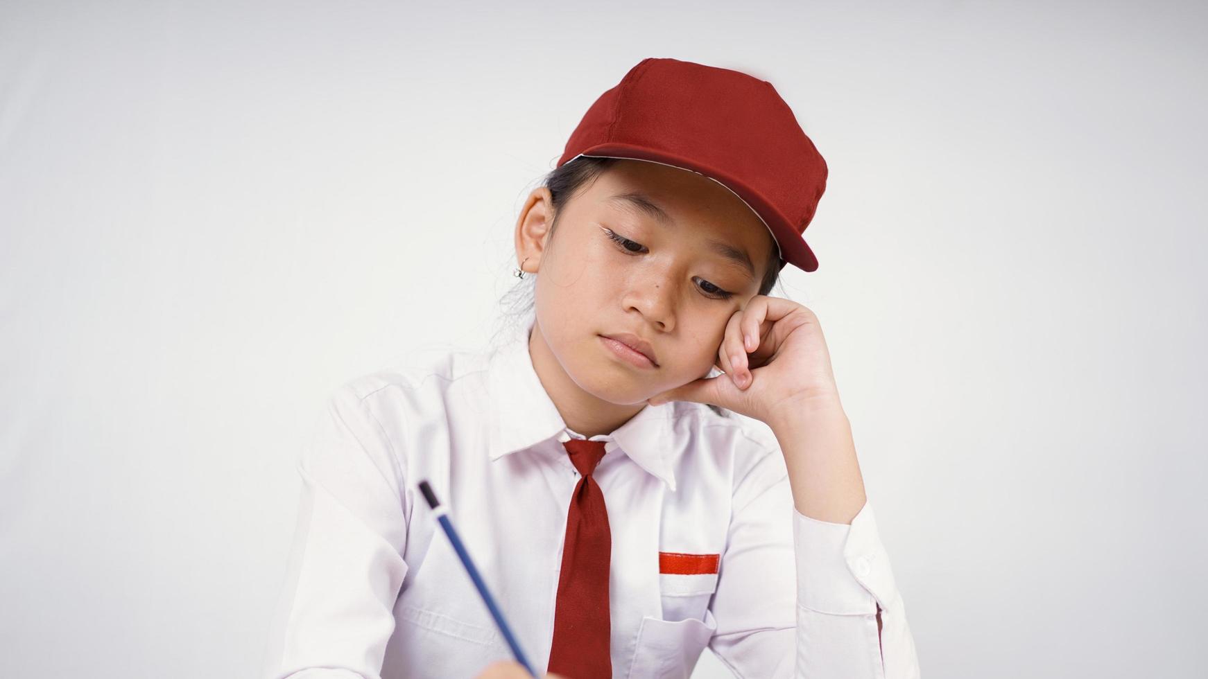 Asian elementary school girl studying until tired isolated on white background photo