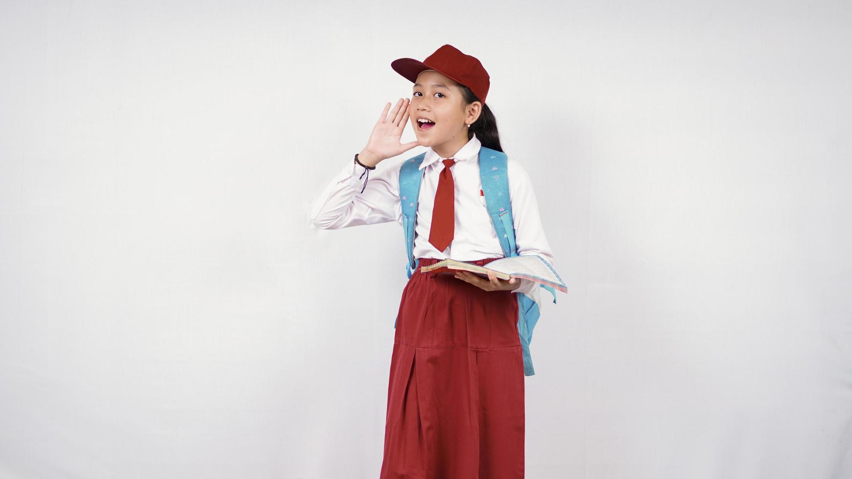 Niña de la escuela primaria gritando al lado aislado sobre fondo blanco. foto