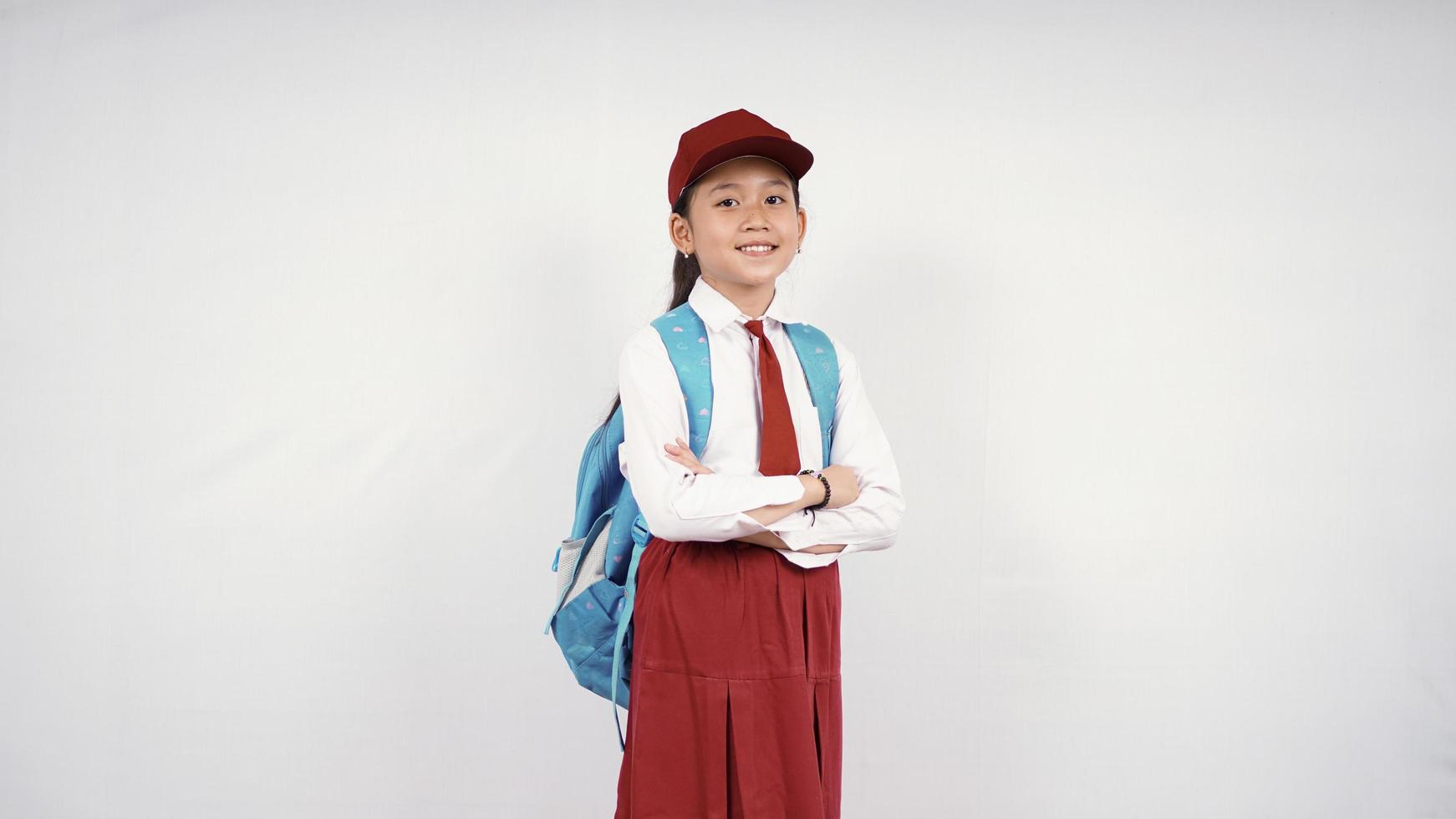 Niña de la escuela primaria asiática dando dos pulgares hacia arriba aislado sobre fondo blanco. foto