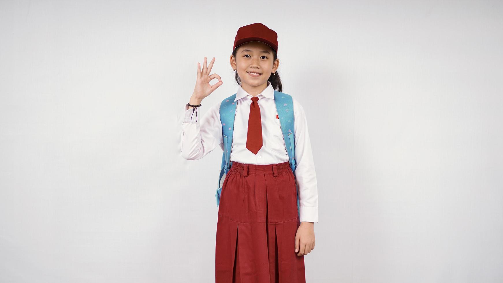 Asian elementary school girl feeling okay isolated on white background photo