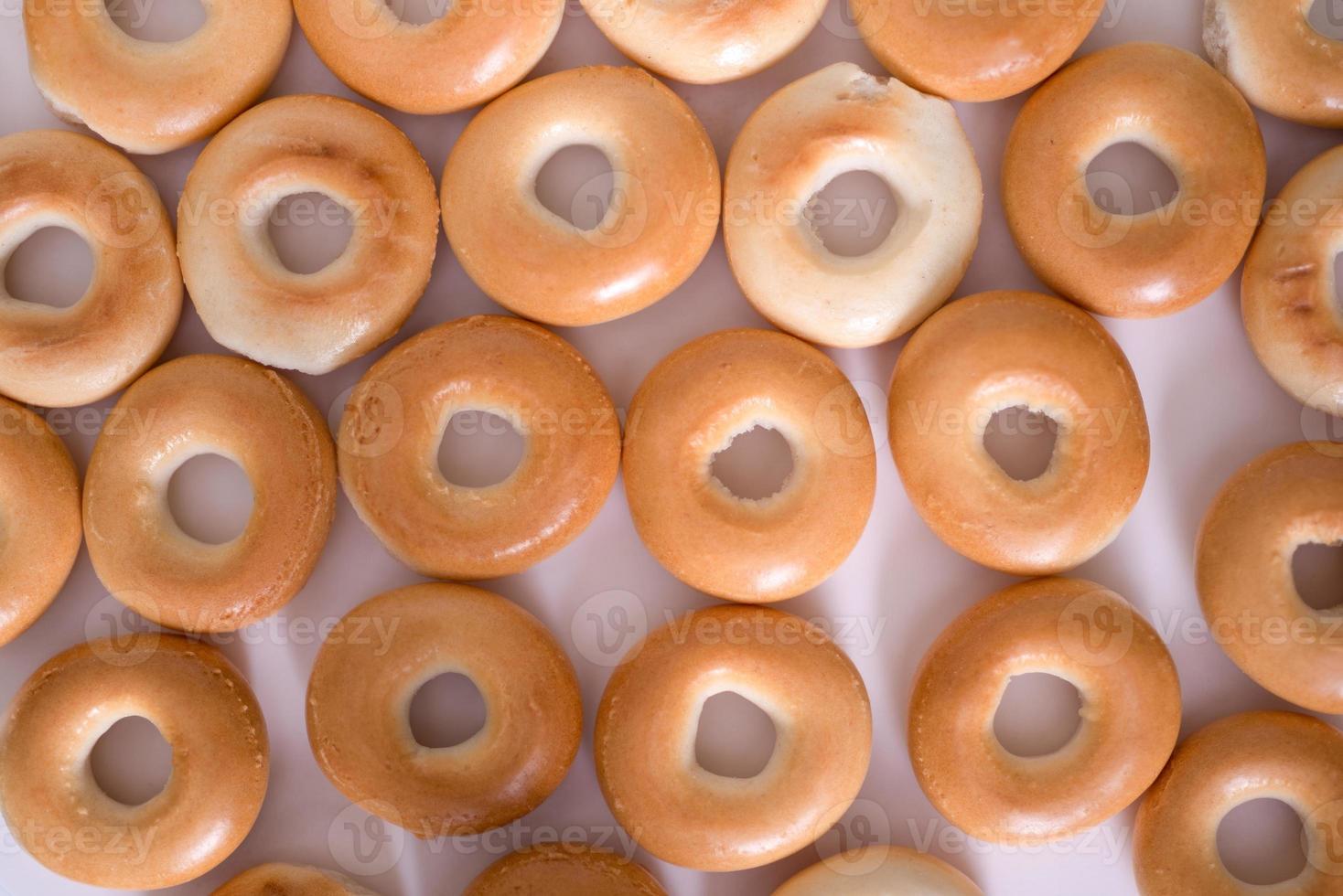 Creative pattern of bagels without sesame seeds on a light background, top view. photo