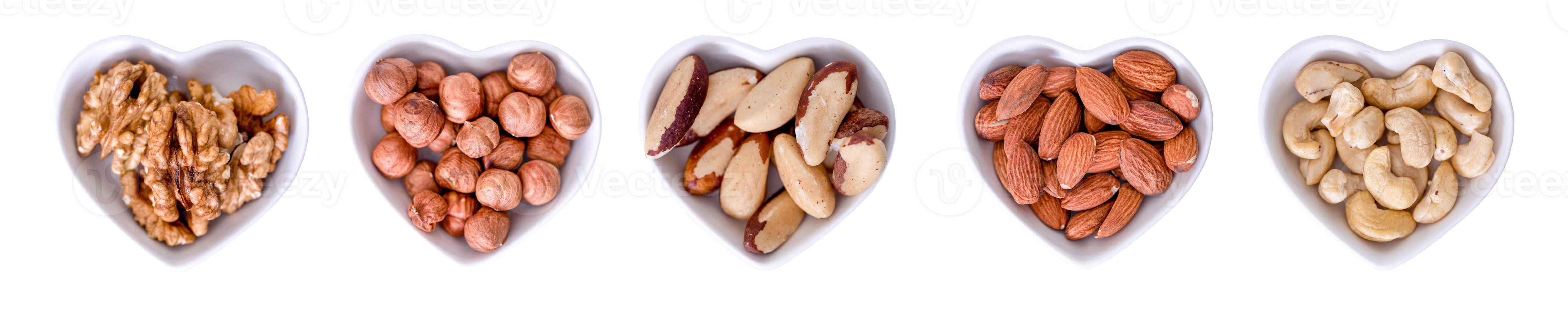 A collection of nuts in cups in the shape of a heart on a white background. photo