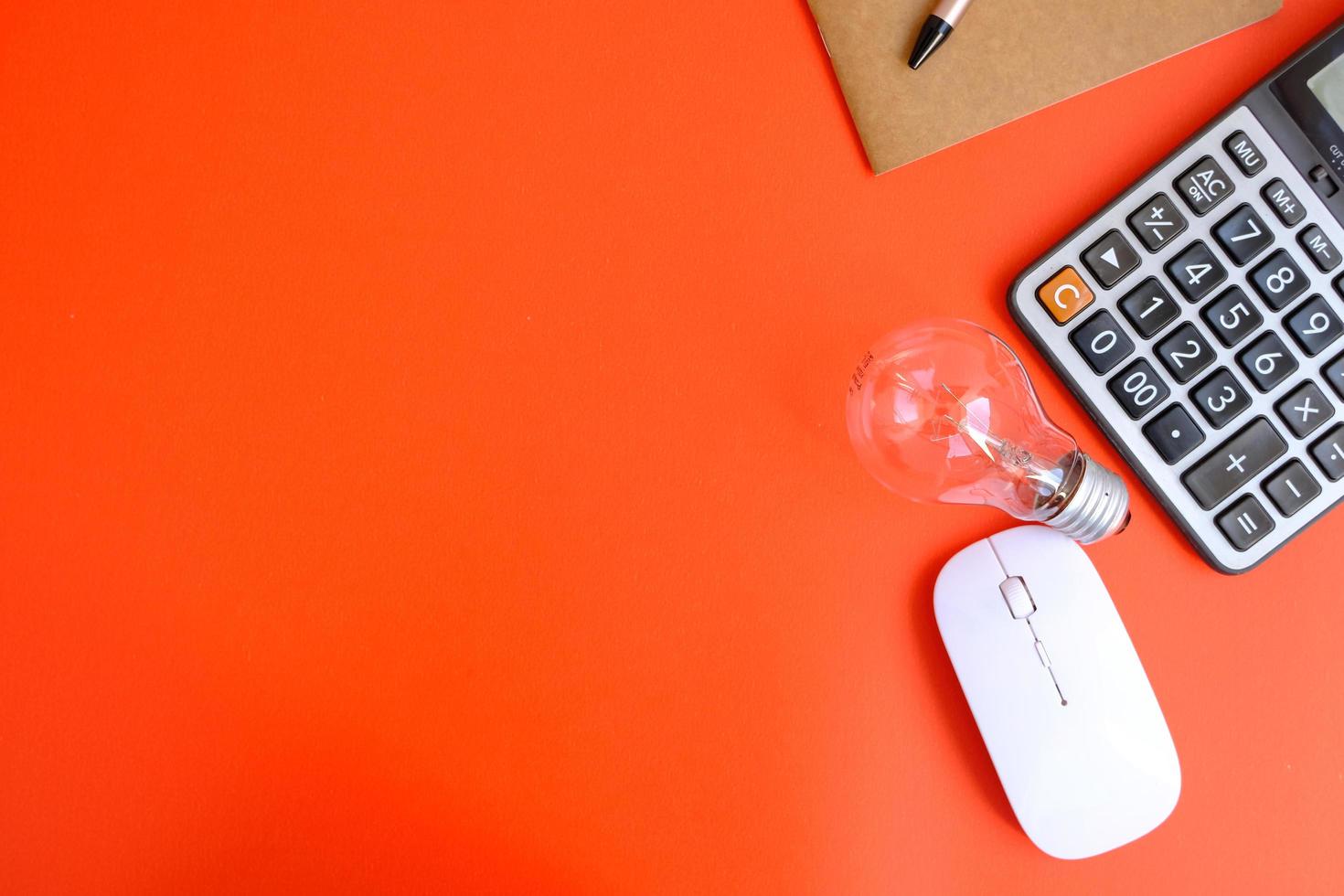 Blank notebook with pen is placed on an office desk table with computer tools and a range of materials. finance and banking background, flat lay, top view photo