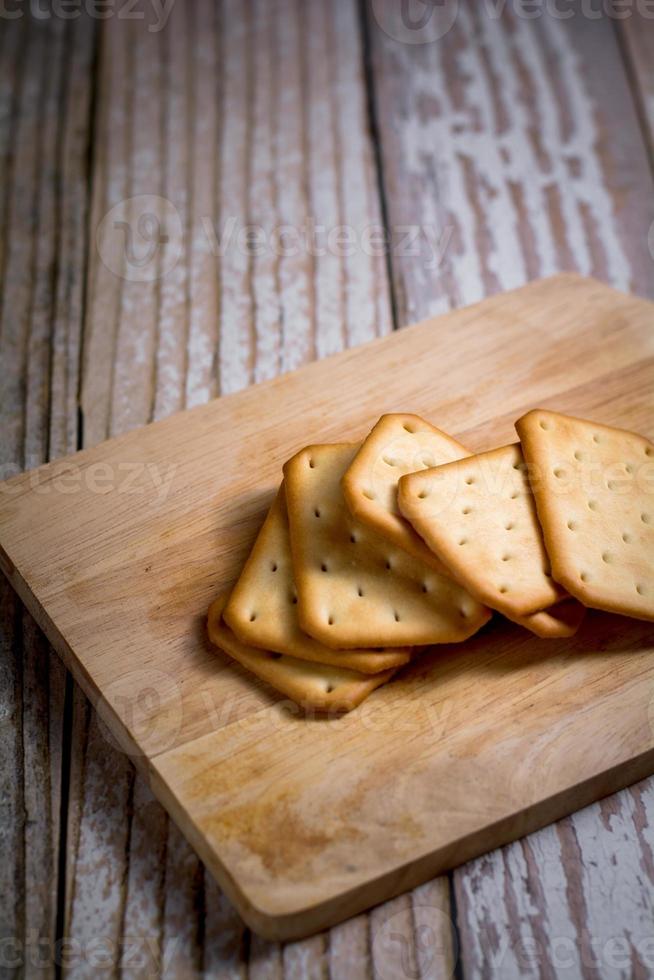 Square of crackers on wooden tray. crispy bread for relaxing time. delicious snack. photo