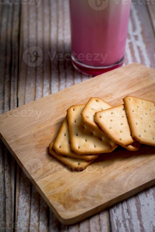 Square of crackers on wooden tray. crispy bread for relaxing time. delicious snack. photo